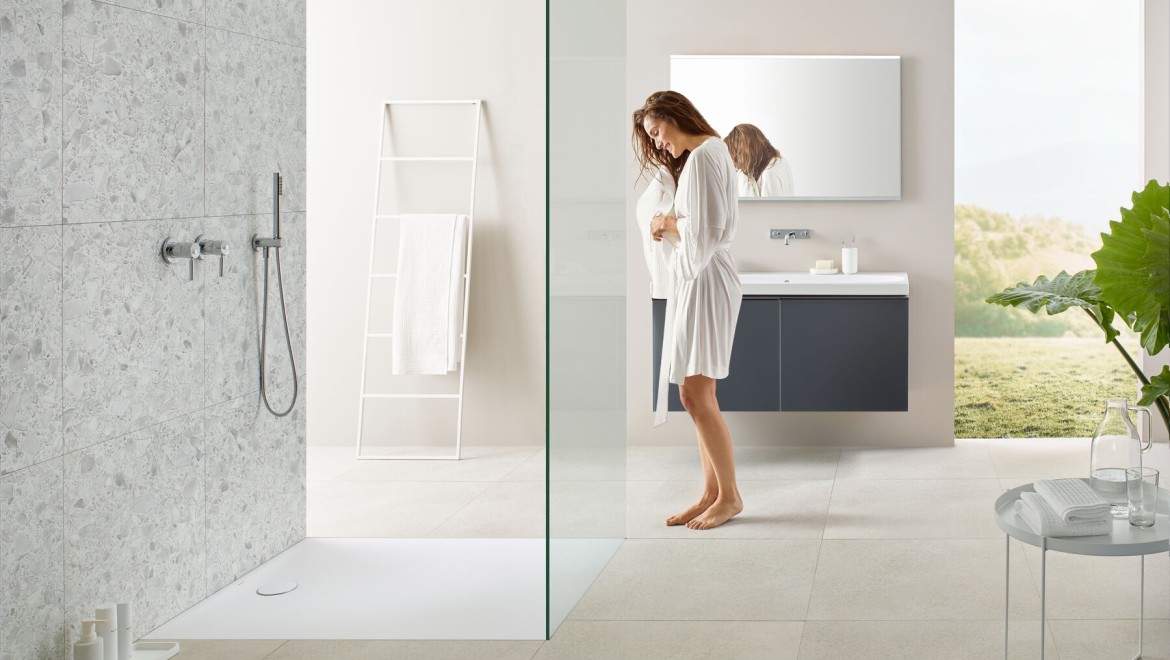 Donna in piedi in un bagno con doccia walk-in