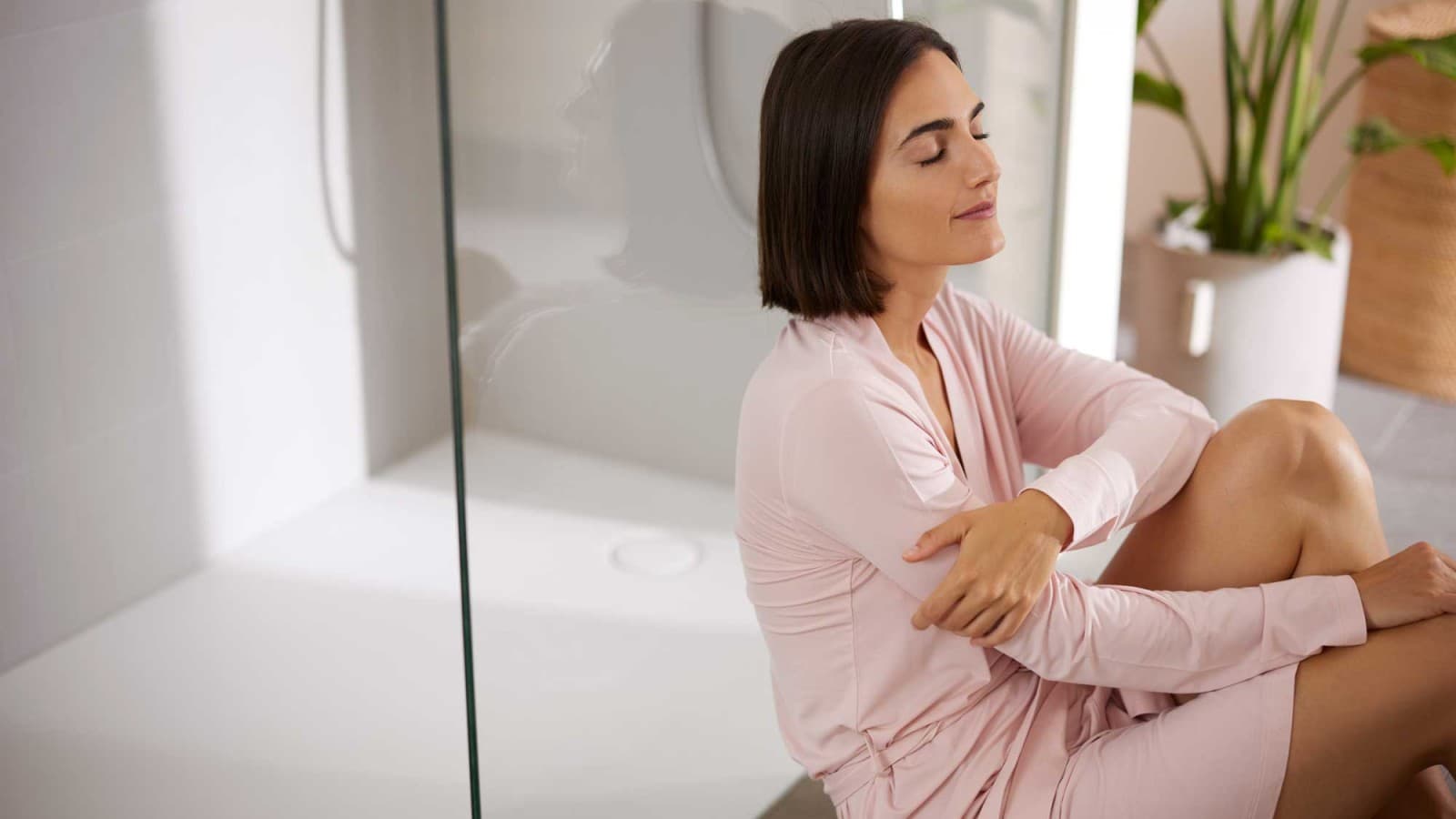 Donna seduta di fronte ad una doccia Donna seduta di fronte ad una doccia