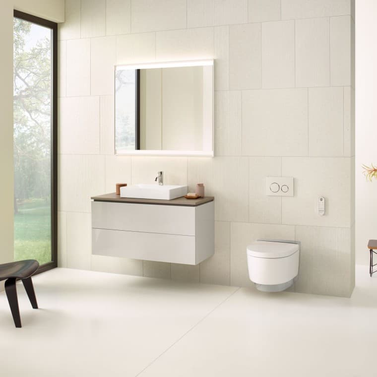 Bagno beige con mobile specchio, mobile sottolavabo, placca di comando e sanitari in ceramica di Geberit Bagno beige con mobile specchio, mobile sottolavabo, placca di comando e sanitari in ceramica di Geberit
